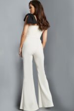 Model wearing Jovani 22589 ivory jumpsuit, back view showcasing the shoulder bow.