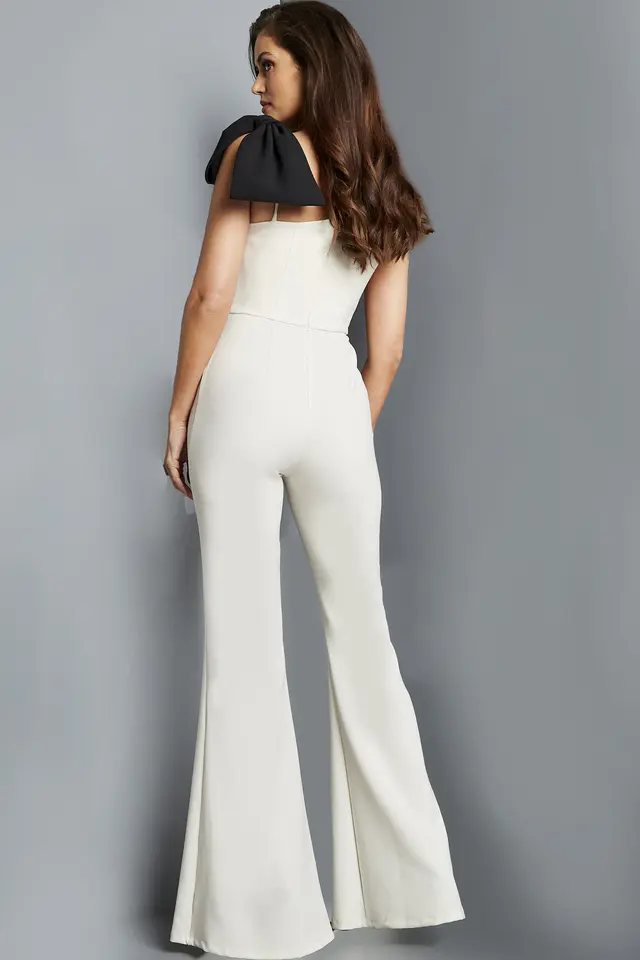 Model wearing Jovani 22589 ivory jumpsuit, back view showcasing the shoulder bow.