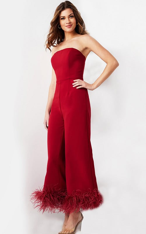 Model wearing Jovani 22590 elegant red strapless jumpsuit with feathered hems, front view.