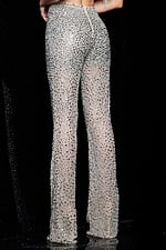 Model wearing Jovani 22781 featuring embellished nude pants and feather detailed top, back view.