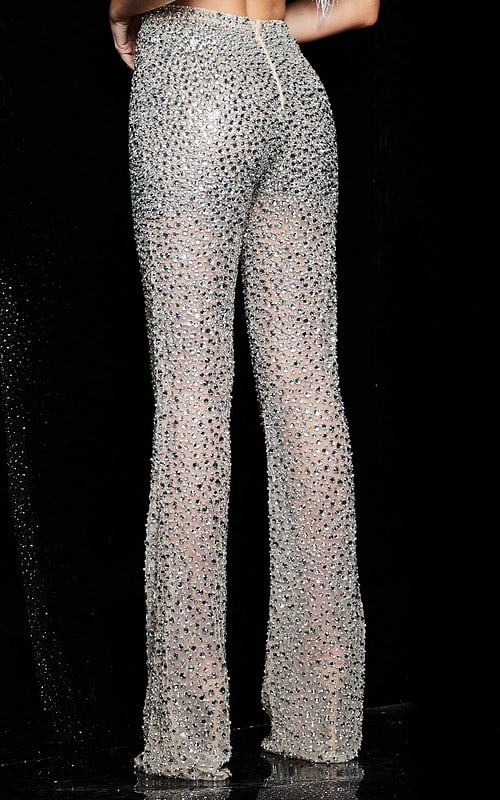 Model wearing Jovani 22781 featuring embellished nude pants and feather detailed top, back view.
