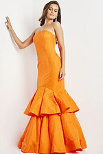 Model wearing Jovani 22921 orange strapless multi-tiered mermaid gown, front view.