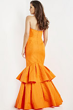 Model wearing Jovani 22921 orange strapless mermaid gown, back view.