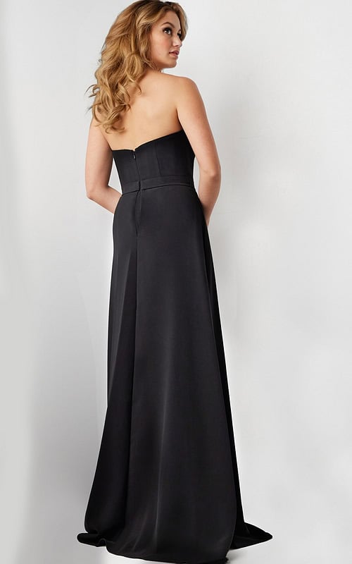 Model wearing Jovani 23150 black gown showing back view with full-length skirt.