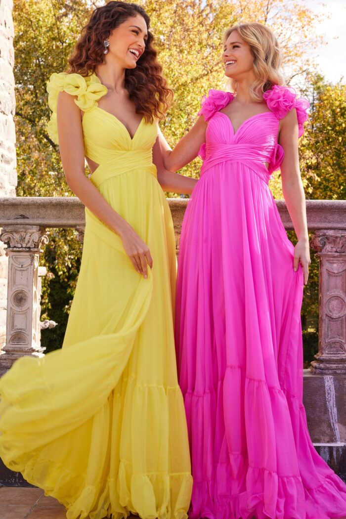 Models wearing Jovani 23322 yellow and pink gowns with floral appliqué and flowing skirts