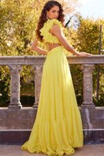 Back view of model wearing Jovani 23322 yellow dress with open back and floral appliqué