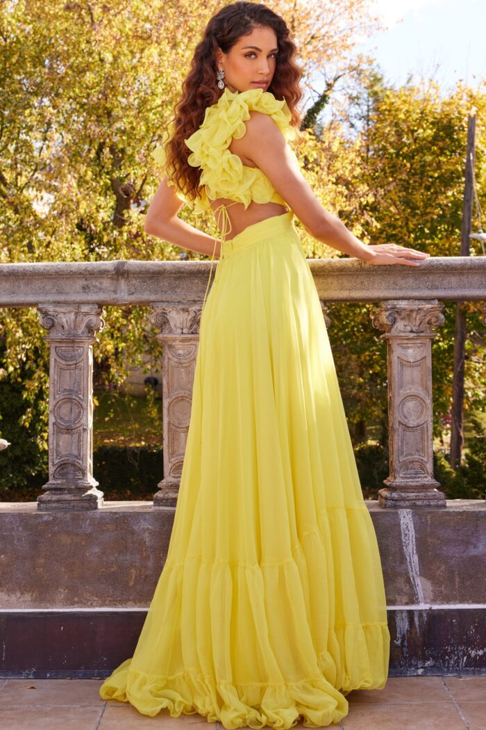 Back view of model wearing Jovani 23322 yellow dress with open back and floral appliqué