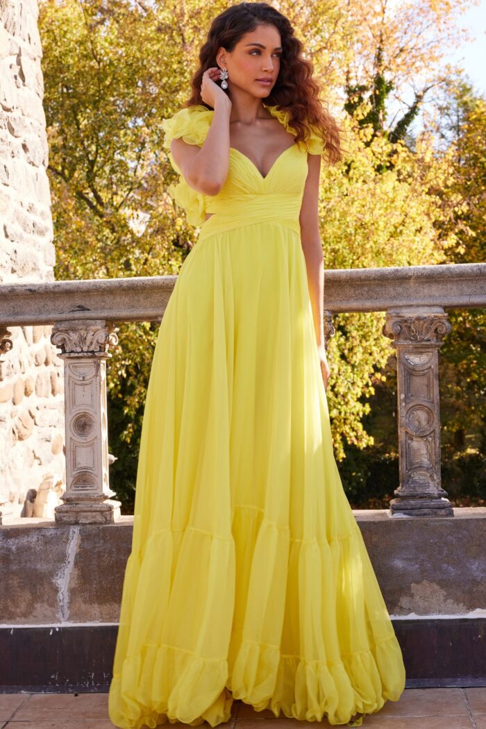 Model in Jovani 23322 yellow gown with sweetheart neckline and floral details