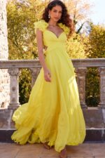 Model wearing Jovani 23322 yellow dress with floral appliqué and layered skirt