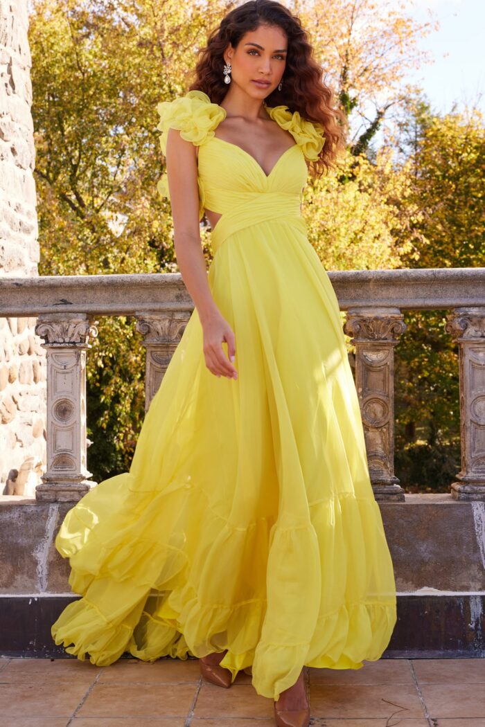 Model wearing Jovani 23322 yellow dress with floral appliqué and layered skirt