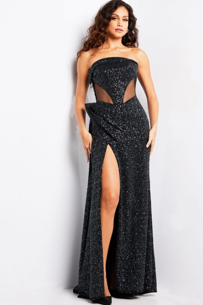 Model wearing Jovani 23388 black strapless gown with high slit and embellishments front view.
