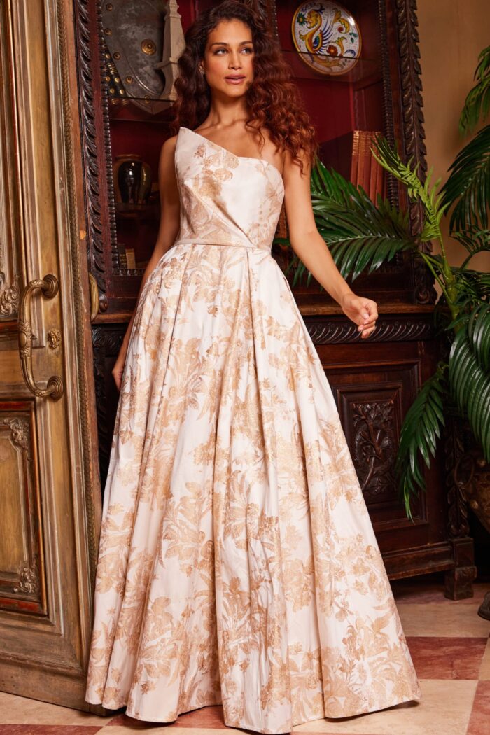 Model in Jovani 23625 gold gown, highlighting front details and one-shoulder.