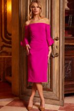 Model showcasing Jovani 23645 fuchsia dress in a mid-length view with bell sleeves.