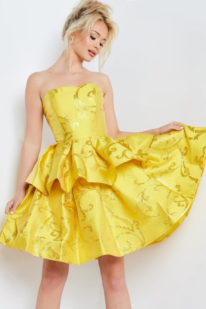 Model wearing Jovani 23743 yellow cocktail dress holding the skirt, emphasizing the jacquard fabric and elegant ruffles.