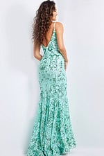 Model showing the back of Jovani 23839 green gown with low back design.