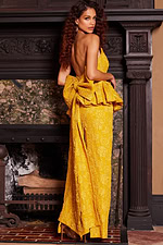 Model wearing Jovani 23849 yellow gown with back view and elegant peplum.
