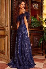 Back view of model wearing Jovani 23884 navy gown with dramatic off-the-shoulder design and sequins.
