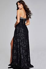 back view of model in Jovani 23892 black gown with high slit and beaded neckline