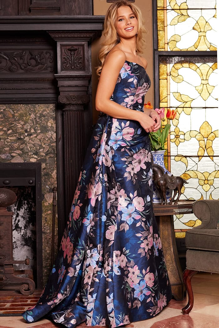 Model in Jovani 23893 gown showcasing the strapless design and floral pattern.