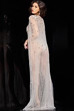 Back view of model wearing Jovani 23895 nude dress showing cape details.