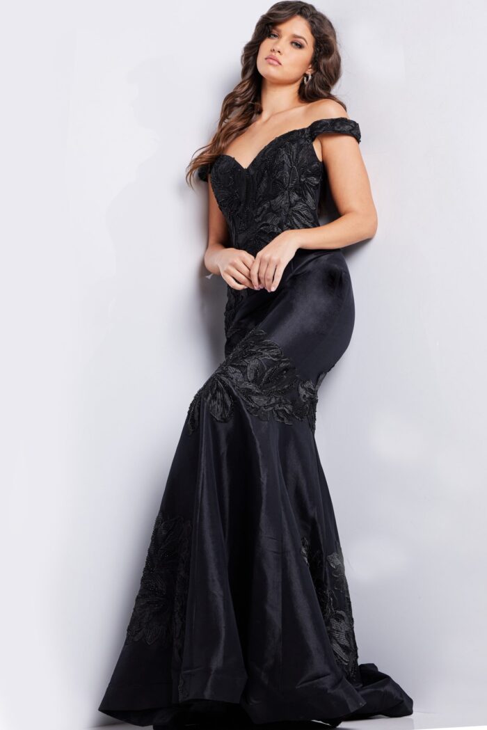 Model wearing Jovani 23928 black dress with floral appliques, angled front view.