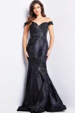 Model wearing Jovani 23928 black dress with off-the-shoulder neckline, front view.