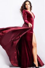 Side view of model in Jovani 23943 burgundy gown, highlighting the elegant flow and high slit.