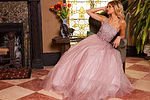 model relaxing in Jovani 24051 blush gown with sparkling bodice