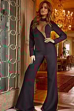 Model wearing Jovani 24297 black jumpsuit with sheer neckline and floor-length wide legs.