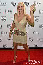 Model wearing Jovani 20711 gold mini dress with V-neckline on the red carpet.