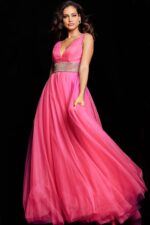 Model wearing Jovani 24564 hot pink gown with flowing skirt, frontal view.