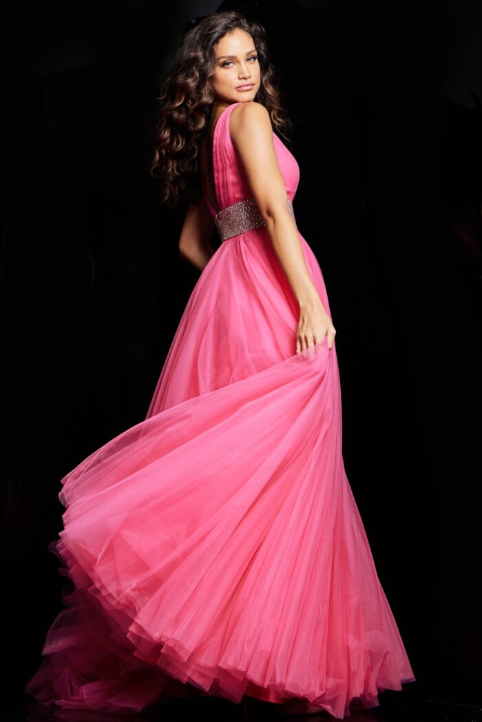 Model wearing Jovani 24564 hot pink gown, back angle view with open back and embellishments.