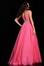 Model wearing Jovani 24564 hot pink gown with open back and embellished waistband, back view.