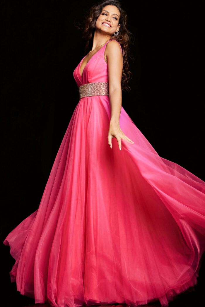 Model wearing Jovani 24564 hot pink gown with deep V-neck and flowing fabric, front view.
