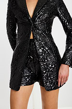 Close-up of blazer romper showing front button detail, floral embossed pattern, and matching shorts.