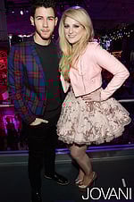 Model wearing Jovani 88259 blush dress with floral embroidery and knee-length flared skirt.