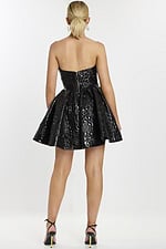 Rear angle of model in glossy black strapless cocktail dress with full A-line skirt.