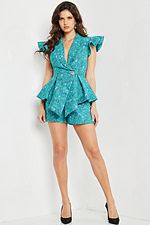 Model wearing Jovani 24623 blue romper with a V-neckline and ruffled cap sleeves.