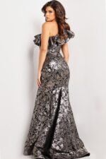 Model wearing Jovani 25676 gray gown back view with fitted silhouette and ruffle shoulder.
