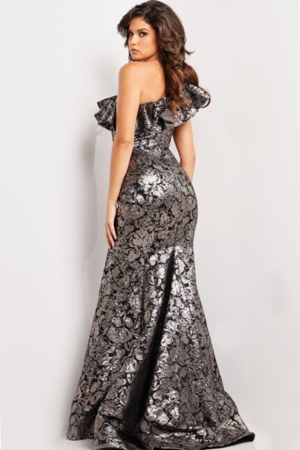 Model wearing Jovani 25676 gray gown back view with fitted silhouette and ruffle shoulder.