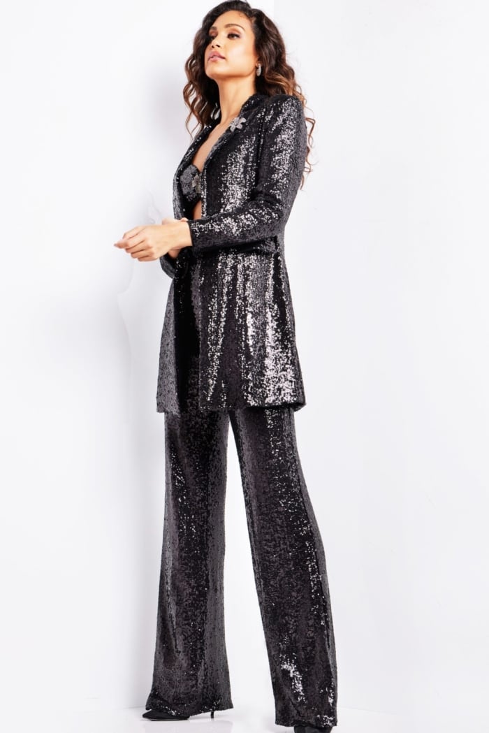 Model wearing Jovani 25749 black sequin pantsuit with blazer and wide-leg pants.