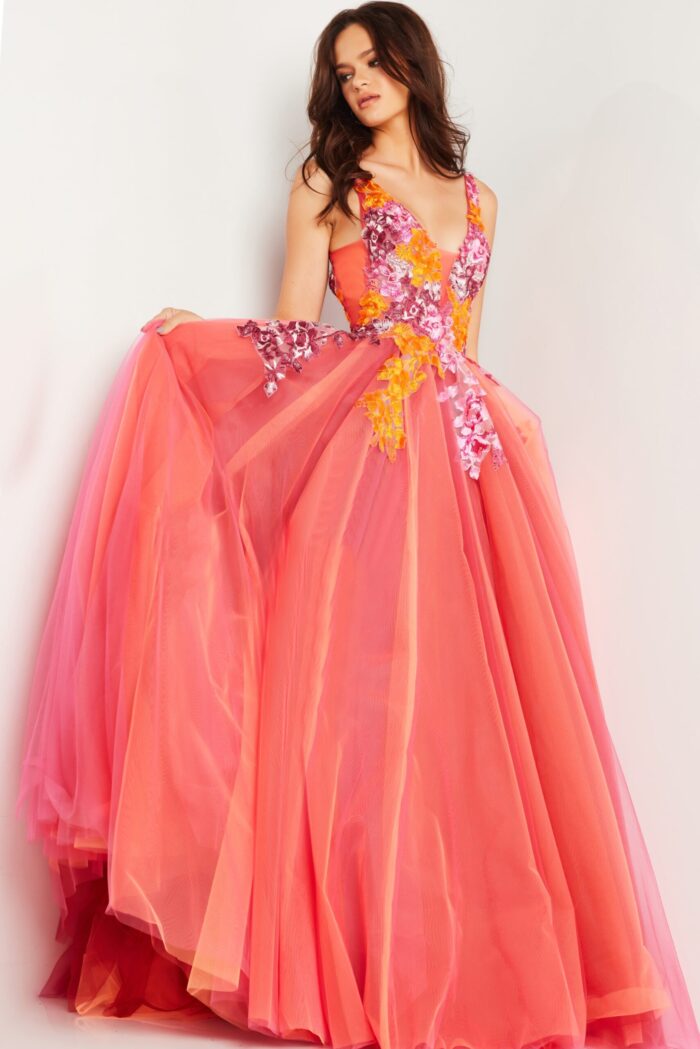 Model highlighting the details of Jovani 25800 orange gown with V-neckline and tulle layers.