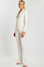 Side view of model in elegant off-white pantsuit with structured fit and satin lapel.