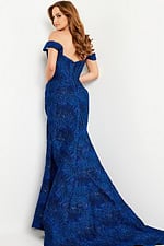 Model wearing Jovani 26017 cobalt blue gown with off-shoulder neckline, back view.