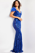 Model in Jovani 26041 royal blue mermaid gown with feather accented shoulders.