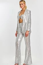 Side view of silver sequin three-piece outfit with sparkling flare pants and open jacket.