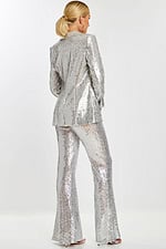 Back view of model in shimmering silver sequin pantsuit featuring tailored jacket and wide-leg trousers.