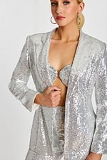 Close-up of sequin blazer and bandeau top with metallic ring detail at the bust.