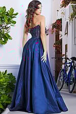 Back view of model in Jovani 26114 navy gown with full-length flowing skirt.