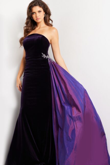 model wearing 26116 purple velvet gown with strapless neckline and dramatic side overlay